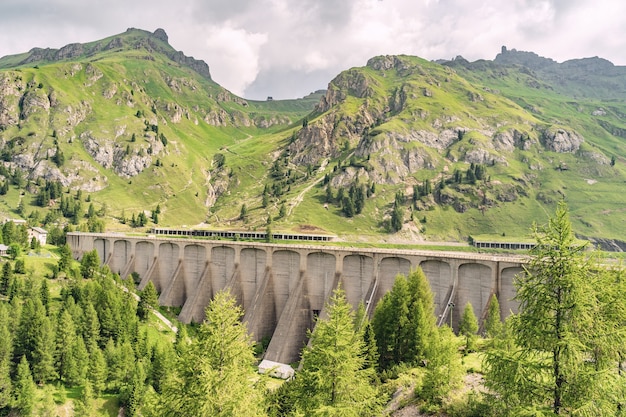 Paisagem paisagística com colina verde e dum nos Alpes