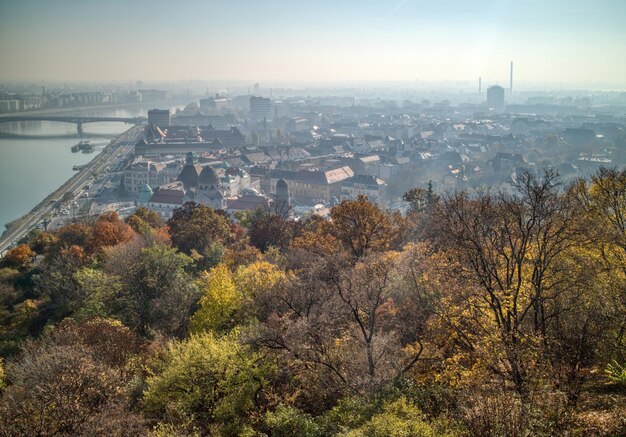 Paisagem panorâmica aérea acima da parte histórica de Budapeste com vista para o rio Danúbio e árvores de outono em uma linha de frente.