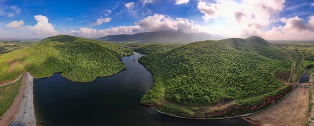 Paisagem panorâmica aérea com colinas verdes, rio e floresta