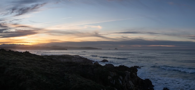 Paisagem panorâmica ao pôr do sol na praia de Valdearenas em Liencres, Cantábria.