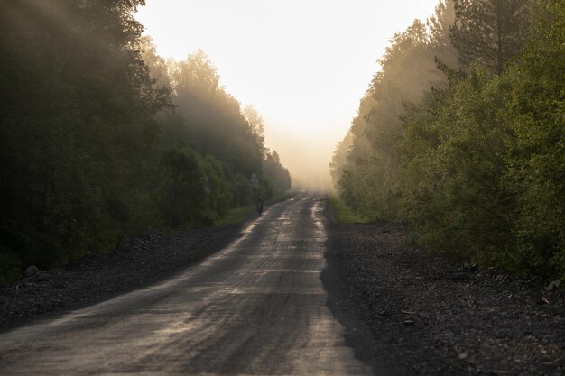 Paisagem pitoresca e nascer do sol acima da estrada enevoada