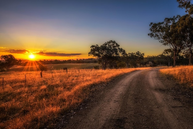 Paisagem rural com estrada de terra rural ao pôr do sol na Austrália