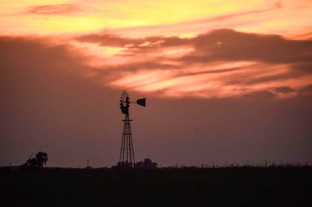 Paisagem rural com moinho de vento ao pôr do sol Pampas Argentina