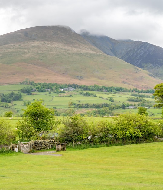 Paisagem rural do campo verde e fundo de montanha sob céu nublado na Inglaterra