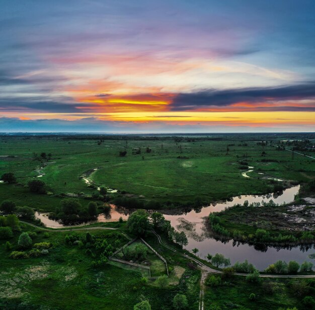 Paisagem rural do pôr do sol do verão com vista aérea do fundo natural do rio e do céu colorido dramático