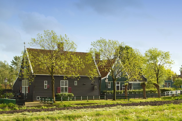 Paisagem rural holandesa de pequenas casas antigas e canal em Zaanse Holanda