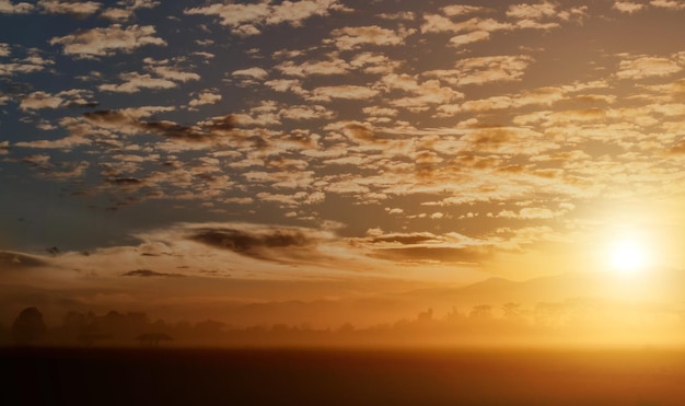 Paisagem rural sob um céu colorido cênico com nuvens ao fundo do pôr-do-sol
