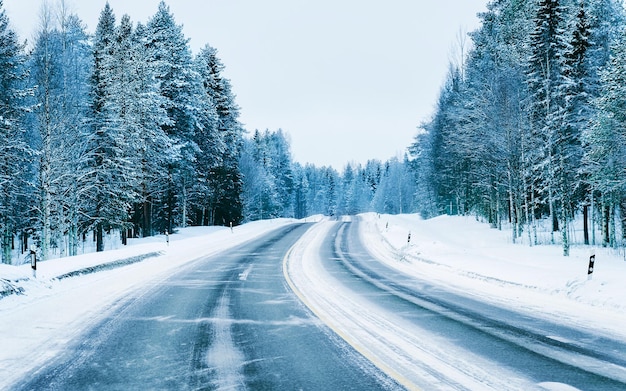 Paisagem sem carros na estrada de neve vazia na Finlândia. Viagem de férias na estrada com a natureza. Cenário com unidade de inverno na viagem de férias para recreação. Passeio de movimento na Europa. Transporte na calçada