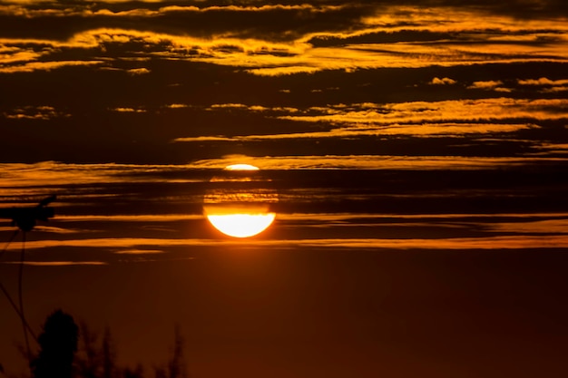 paisagem sonora com sol e luz laranja, céu dramático com luz dourada e nuvens densas