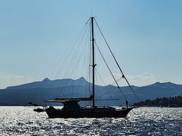 Paisagem tranquila e conceito de natureza costeira, barcos, montanhas e céu azul no horizonte ao pôr do sol