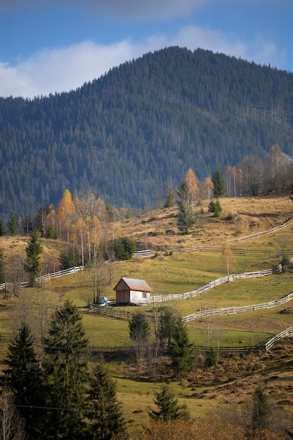 Paisagem ucraniana de belas montanhas. Pasto e velha casa de madeira em um fundo de montanhas. Cárpatos, Ucrânia