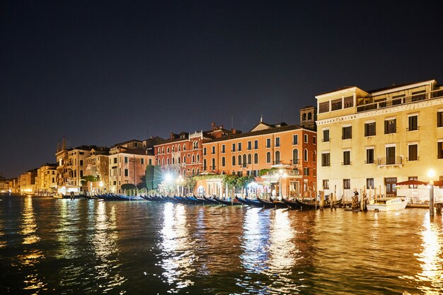 Paisagem urbana de noite de edifícios coloridos de cidade de veneza na água