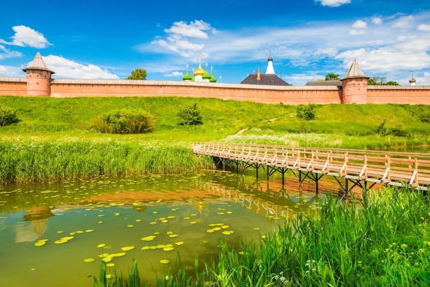 Paisagem urbana de suzdal em um dia de verão. panorama da velha cidade histórica russa com arquitetura tradicional e ponte de madeira sobre o rio. o anel de ouro da rússia.