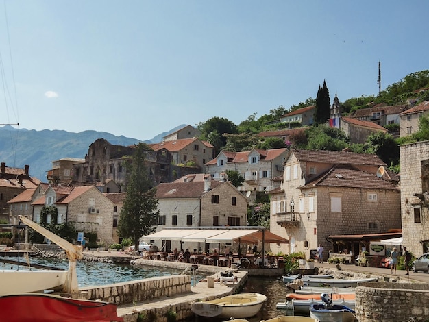 Paisagem urbana diurna com mar e montanhas na cidade velha de Perast Montenegro