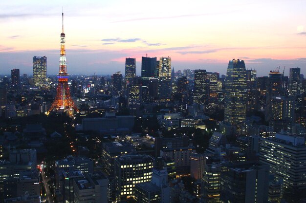 Foto paisagem urbana iluminada contra o céu durante o pôr-do-sol