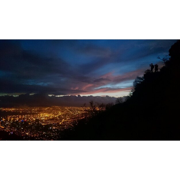 Foto paisagem urbana iluminada sob um céu mal-humorado