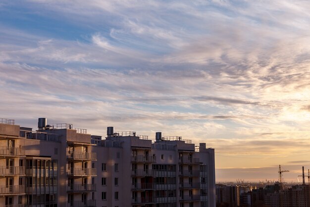 Paisagem urbana industrial à noite ao pôr do sol. Lindo céu azul, edifícios comerciais criativos e edifícios residenciais. Imagem panorâmica de altura