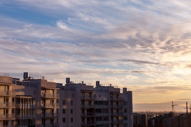 Paisagem urbana industrial à noite ao pôr do sol. Lindo céu azul, edifícios comerciais criativos e edifícios residenciais.