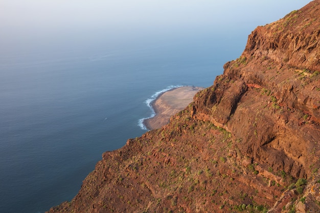 Paisagem vulcânica cênico do litoral, penhascos no parque natural de Tamadaba, Ilhas Canárias grandes, Espanha.