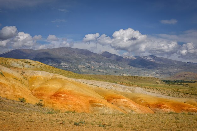 Paisagens marcianas nas montanhas Altai, rochas multicoloridas contra um céu azul com nuvens brancas