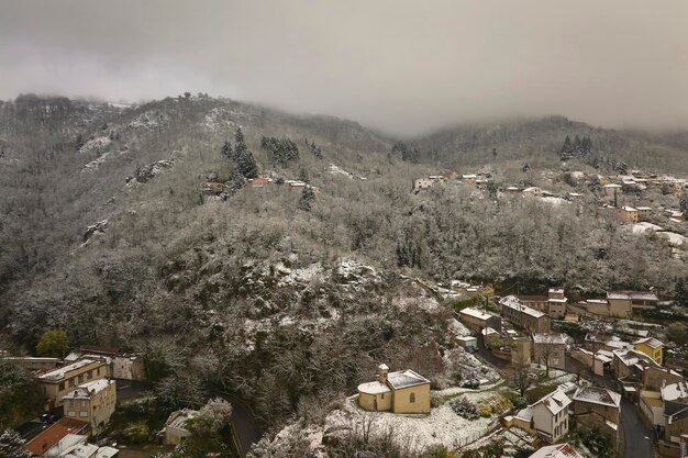 Paisaje aéreo invernal del denso centro histórico de la ciudad de Thiers en el departamento de PuydeDome región de AuvergneRhoneAlpes en Francia Tejados de edificios antiguos y calles estrechas en nevadas