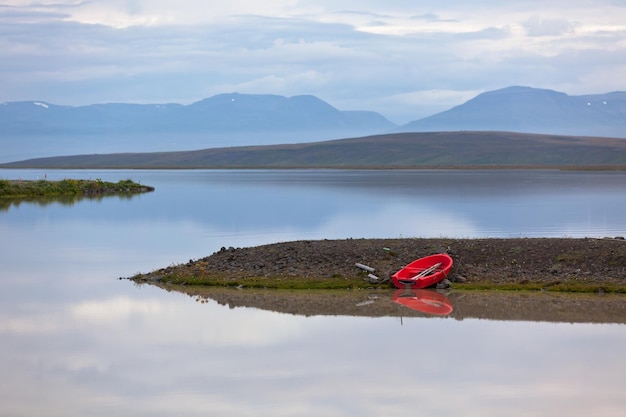 Paisaje de agua de Islandia con barco rojo