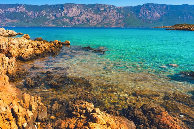 Paisaje de agua de mar azul clara y costo de piedra.