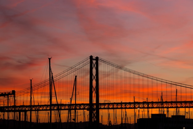 Paisaje al atardecer en la ciudad con puente y yates