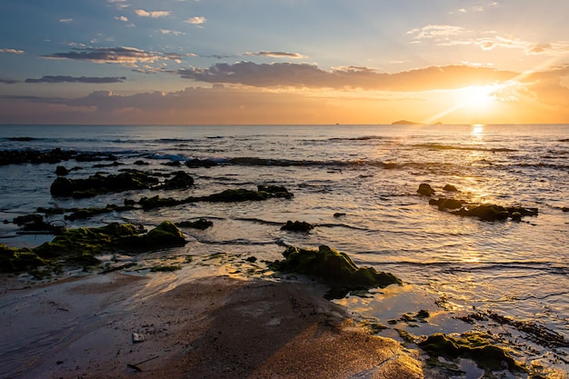 Paisaje al atardecer en las rocas de la playa en primer plano