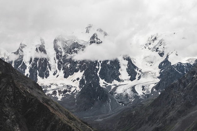 Paisaje alpino atmosférico con un enorme glaciar colgante en una montaña gigante