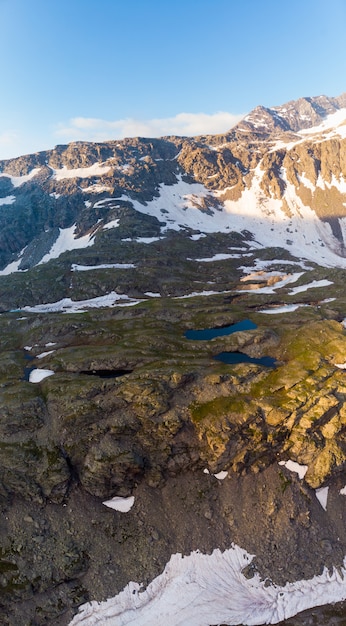 Paisaje alpino de gran altura con majestuosas cumbres rocosas. Panorama aéreo al amanecer. Alpes, Andes, Himalaya concepto
