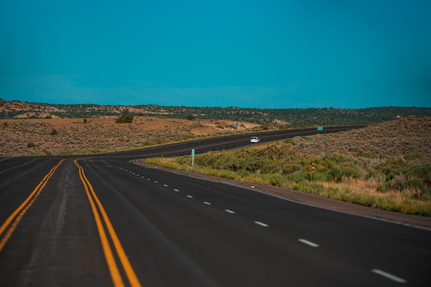 Paisaje americano natural con carretera asfaltada hasta el horizonte.