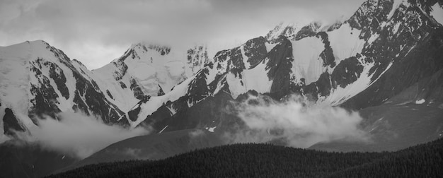 Paisaje en blanco y negro. Picos de las montañas cubiertas de nieve. Viajar por la montaña, escalar.