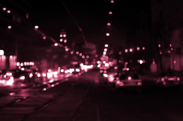 Paisaje borroso de la imagen de la ciudad nocturna tonificada en color viva magenta del año