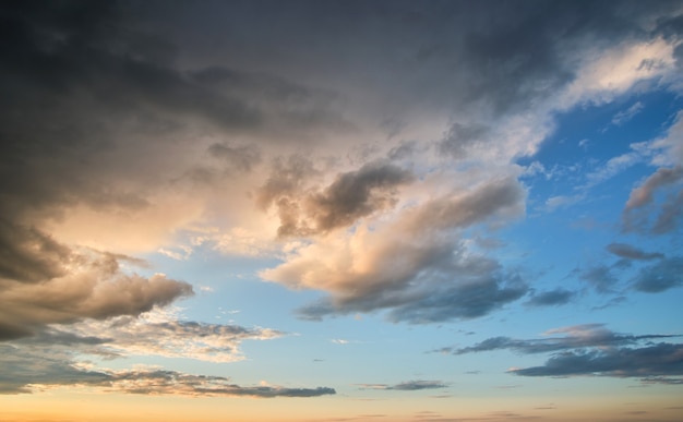 Paisaje brillante de nubes oscuras en el cielo amarillo del atardecer en la noche.