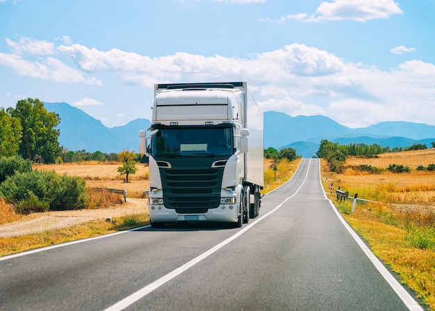 Foto paisaje con camión en la carretera en carbonia cerca de cagliari en cerdeña en italia. transporte en camión entregando algo de carga.