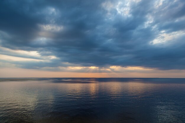 Paisaje de campo de una hermosa puesta de sol y nubes sobre el río