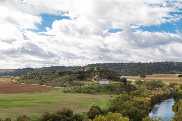 paisaje con campos y una casa en otoño