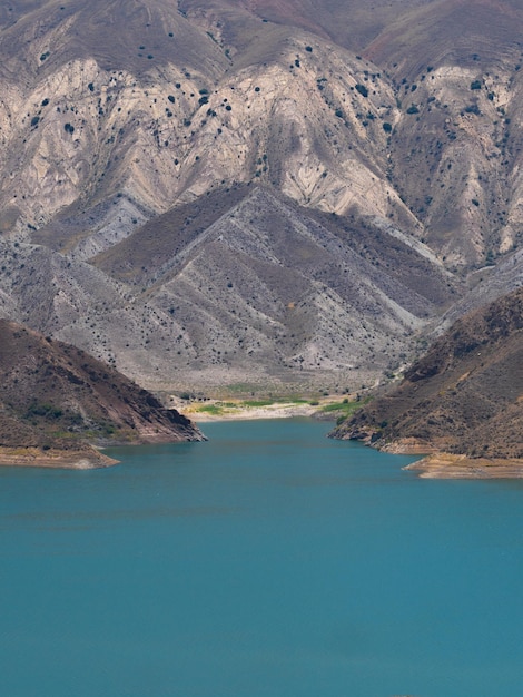 Paisaje de cantera árida y costa de lago azul profundo