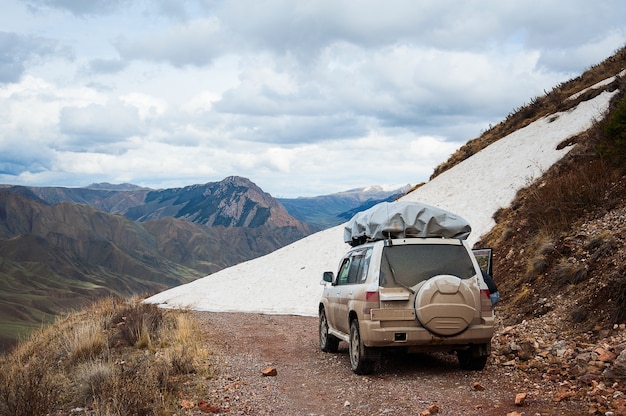 Paisaje de carretera de nieve de montaña. Jeep 4x4 en un paso de montaña