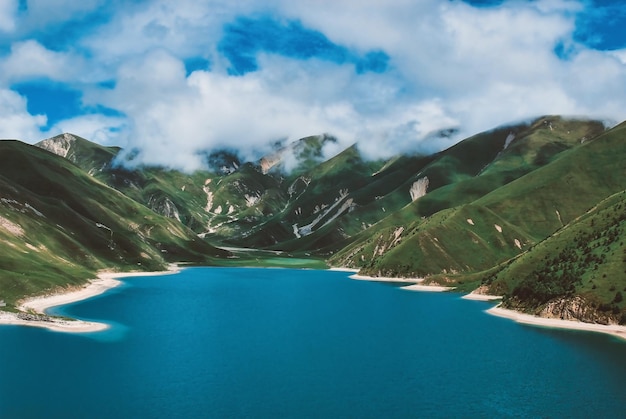 Paisaje de cielo azul y mar turquesa con montañas y nubes blancas