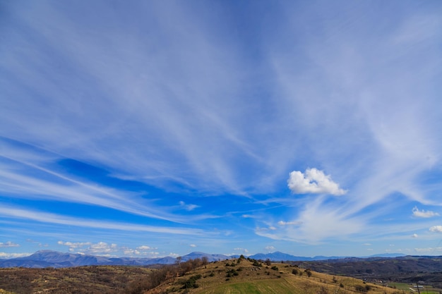 Paisaje con cielo azul y nubes de plumas.