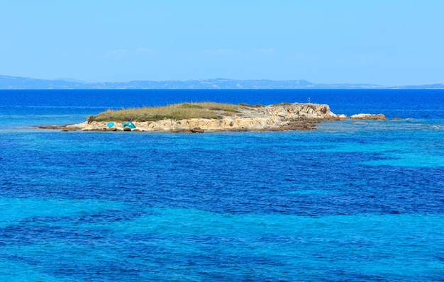 Paisaje de la costa del mar Egeo con isla rocosa, vista cerca de la playa de Karidi (Chalkidiki, Grecia).