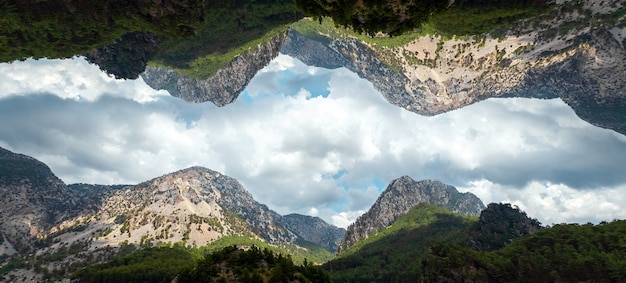 Paisaje creativo, diseño moderno, montañas reflejadas en el cielo, mundos paralelos. Copie el espacio.