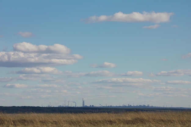 Paisaje con empresa industrial en el horizonte con hermoso cielo nublado - concepto de ecología