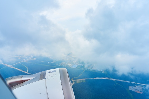 Foto paisaje de esponjosas nubes blancas en un cielo azul oscuro con una parte de un avión. vista desde el avión a gran altura.