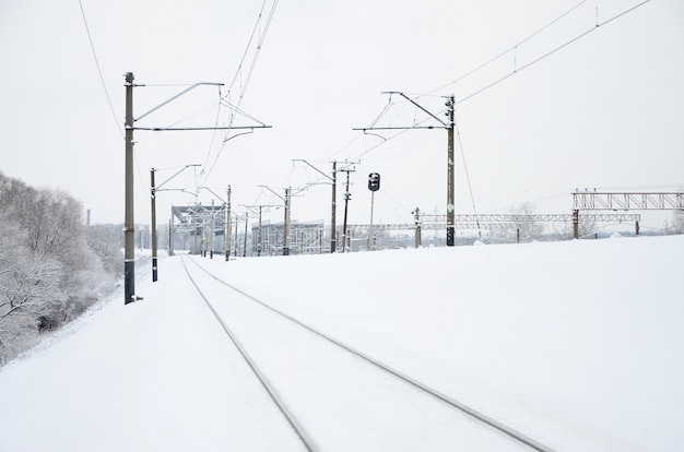 Paisaje ferroviario de invierno, pistas ferroviarias en el país industrial cubierto de nieve.