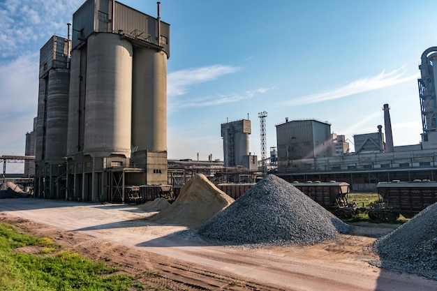 Paisaje gris industrial contaminación ambiental residuos de fábrica de cemento Grandes tuberías de la planta industrial montañas de arena y escombros