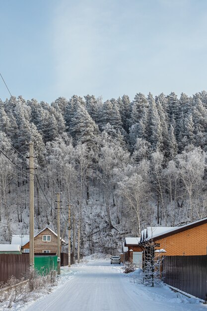 Paisaje de un hermoso pueblo pequeño de casas de madera, carretera, coche. Hermoso bosque mágico y ciudad.