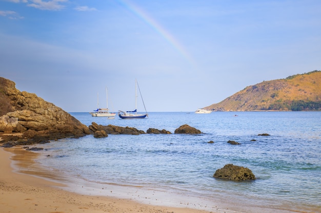 Paisaje hermoso del verano con el arco iris y las naves sobre el mar en la provincia de Phuket en Tailandia.